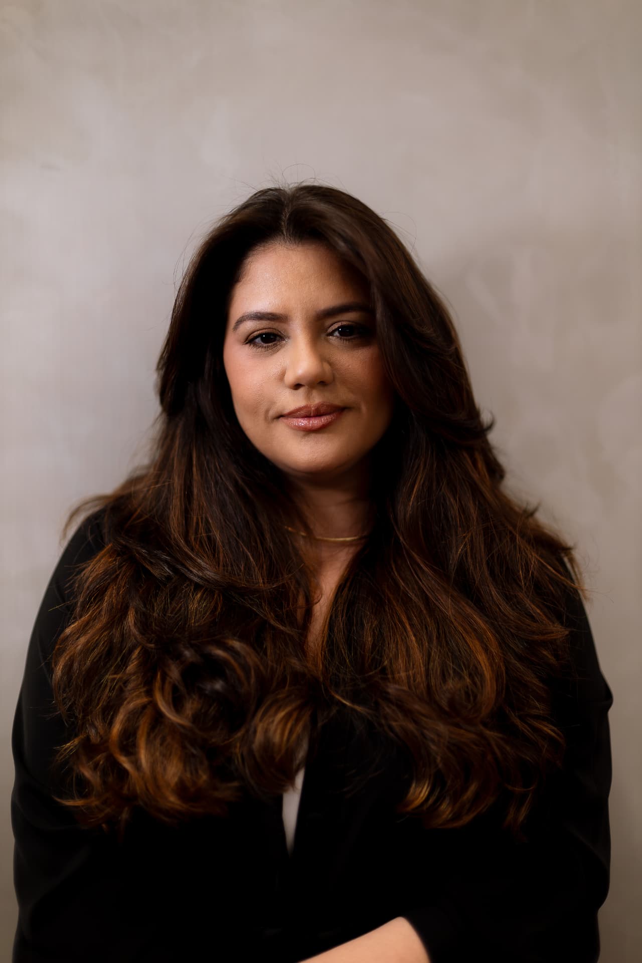 Raquel Tavares sentada em poltrona clara, com cabelos longos